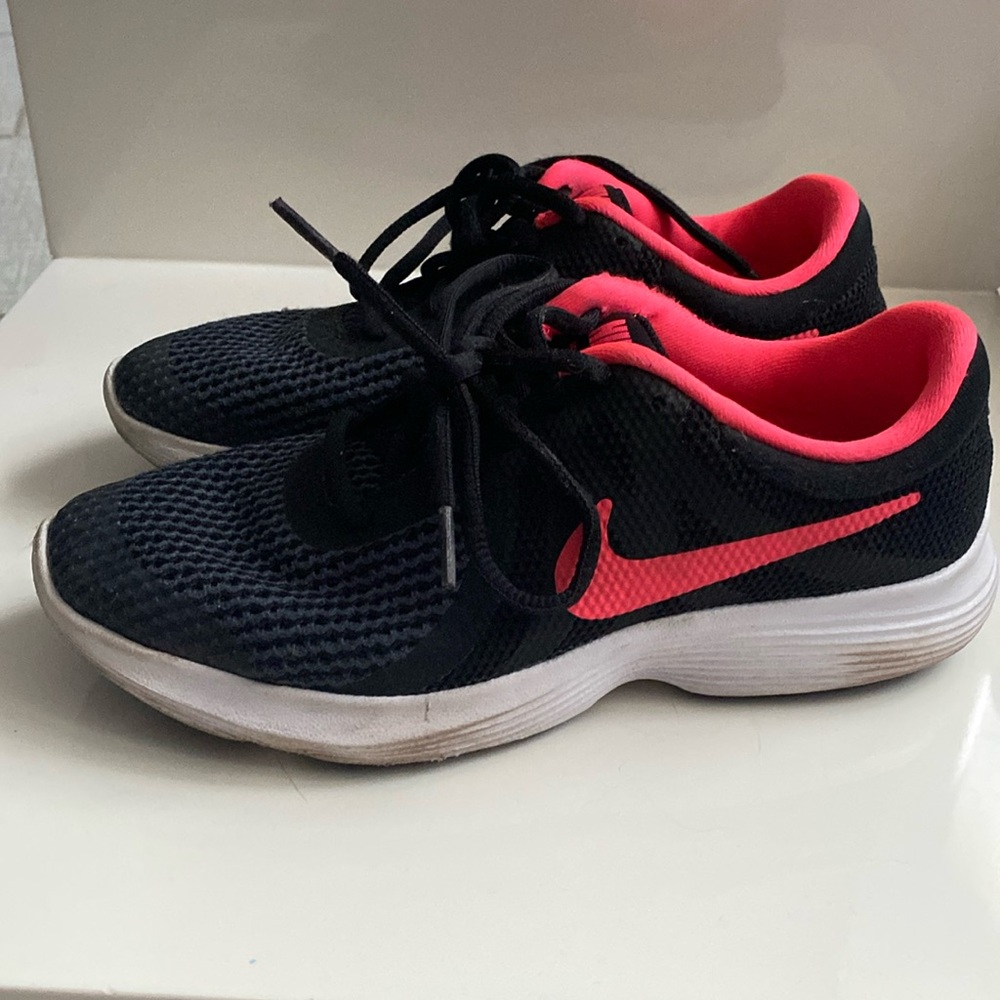 Sneakers by Nike.  Revolution 4. Size 4Y.  Black with hot pink.